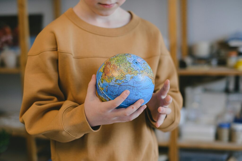 A child carefully holding a globe, symbolizing global education and exploration.